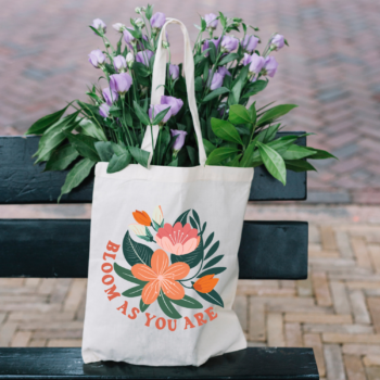 A vibrant Bloom As You Are Boho Flower Tote Bag with floral patterns on sturdy canvas fabric.